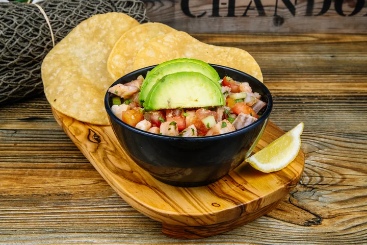 Ceviche topped with avocado and served with crisp tostadas