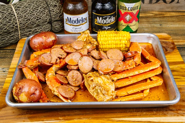 A seafood tray with crab, shrimp, sausage, and corn