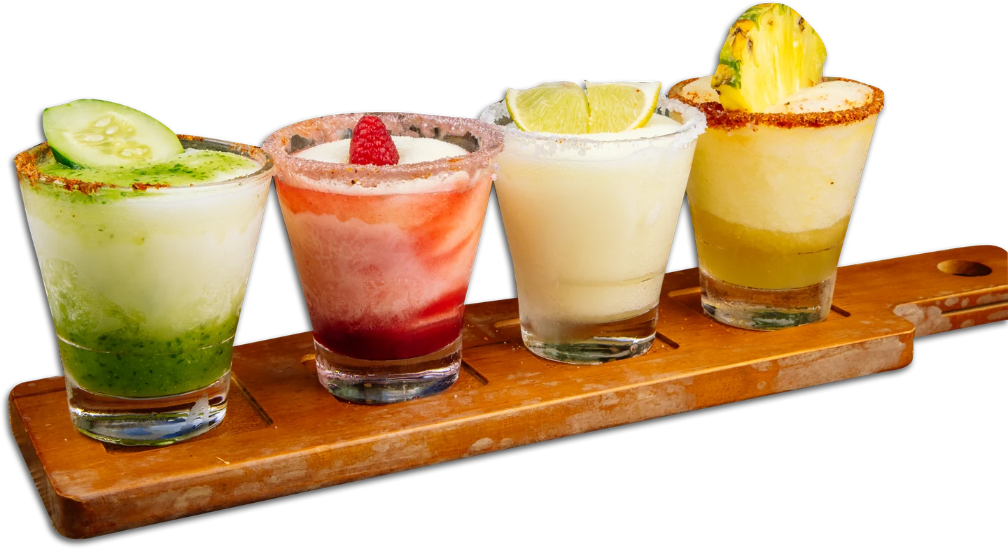 Four colorful margaritas served together on a wooden flight board