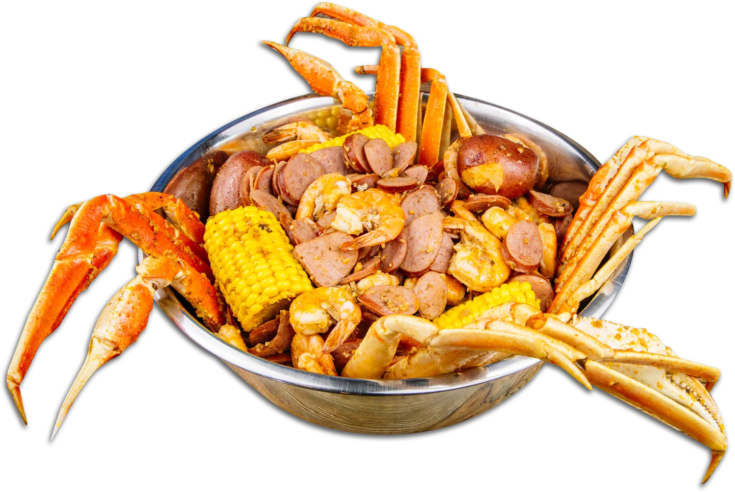 A bowl piled with crab legs, shrimp, corn, sausage, and potatoes
